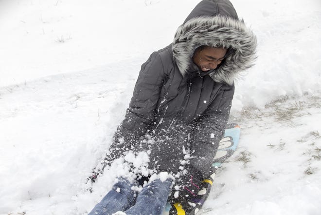 Naomi Daniels, 18, comes to a stop after coming down the sled hill at Reuben Aldeen Park in Rockford, on Monday, March 13, 2017. "It's nice to finally have snow", said Daniels before she dove head first down the hill. About two inches of snow fell in Rockford. [ARTURO FERNANDEZ/RRSTAR.COM STAFF]