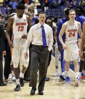 Florida head coach Mike White leaves the court with Kevarrius Hayes (13) and Canyon Barry (24) after Florida was upset by Vanderbilt 72-62 in overtime at the Southeastern Conference tournament Friday, March 10, 2017, in Nashville, Tenn. Florida snagged the No. 4 seed in the NCAA Tournament, but is considered an underdog. [THE ASSOCIATED PRESS / MARK HUMPHREY]