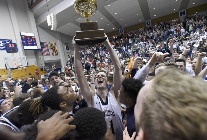 FILE - In this Tuesday, March 7, 2017, file photo, Mount St. Mary's forward Will Miller, center, celebrates with teammates after beating St. Francis (Pa.) 71-61 in the NCAA college basketball Northeast Conference Tournament championship, in Emmitsburg, Md. With the win, Mount St. Mary's earned an automatic berth to the NCAA Tournament. The 67-game March Madness basketball tournament begins Tuesday, March 14, with many games taking place during the work day. All of the games will be available online. For many of the early-round games, though, youþÄôll need a password through your cable or satellite TV subscription. (AP Photo/Steve Ruark, File)