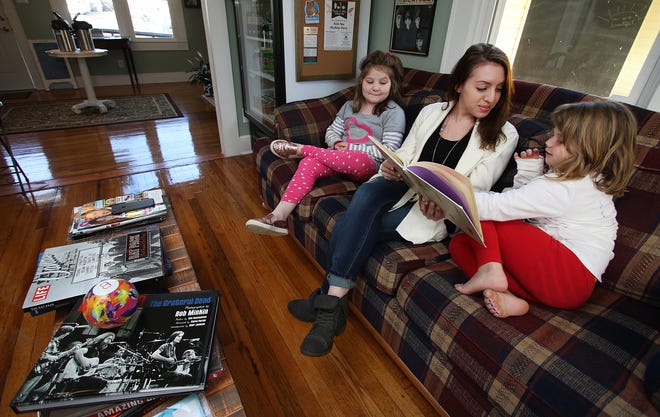 Brittany LaDue reads to Rachael Weathers (left) and her sister, Jillian Weathers, during the daily story time at Pearlee & Cille's Tuesday morning. The Davis Street shop in Belmont is a kid-friendly, dog-welcoming coffee shop and ice cream parlor. [MIKE HENSDILL/THE GAZETTE]