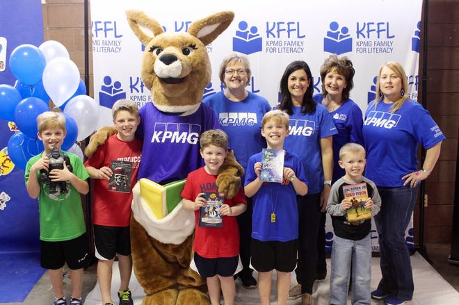 The KFFL book fair mascot "Kiffle" poses with Sheri Boehm, Lee Anne Sciambra, Debbie Ozanus and Lisa Gorham of KPMG. Some kiddos couldn't help but jump in the photo, last minute.