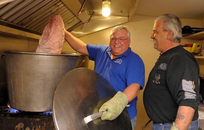 Corky Row Club Past President Steve Omerod hefts some of the 1,500 pounds of corned beef that he and Vice President Wayne McAlister prepared in the club's kitchen for St. Patrick's Day in 2014.