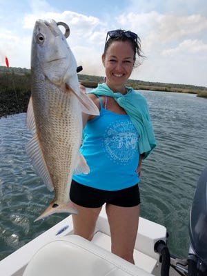 Astarte Sol from New Mexico holds up a 6-pound redfish caught while fishing in Flagler County last week. [NEWS-TRIBUNE/CAPT. MIKE VICKERS]