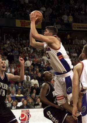 Florida's Mike Miller (13) puts up the game-winning shot in overtime as Butler's Scott Robisch (40) and Thomas Jackson (5) look on during their NCAA East Regional first round game at the Joel Coliseum, Friday, March 17, 2000, in Winston-Salem, N.C. Miller's shot went in at the buzzer leading the Gators to a 69-68 win. [AP Photo/Chuck Burton]