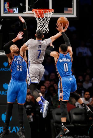 Jeremy Lin drives for a bucket while the Thunder's Taj Gibson and Russell Westbrook defend. (AP Photo)