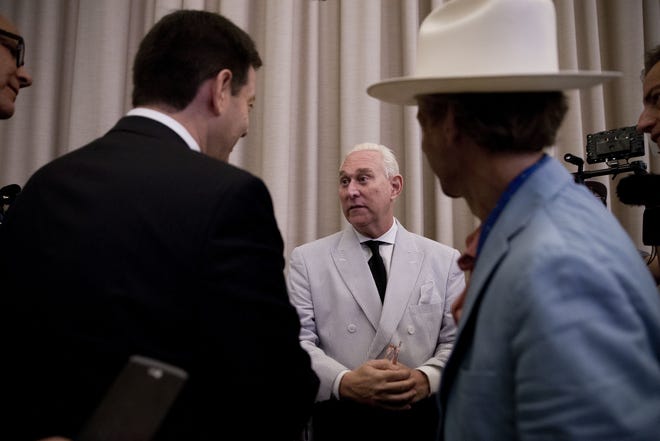 In this photo taken July 16, 2016, Roger Stone, an adviser to Donald Trump, center, speaks to reporters in New York. Stone says he believes his contacts with a Russian-linked hacker who took credit for breaching the Democratic National Committee were obtained through a FISA warrant. THE ASSOCIATED PRESS