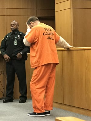 David Broxterman, 58, a former professor at Polk State College, buried his face in his hand Thursday as Circuit Judge Jay Yancey sentenced him to five years in prison for faking his PhD so he could teach at the college.