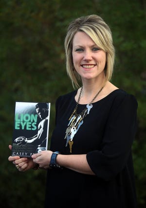 Casey Peeler holds her latest book "Lion Eyes." It's now available for digital readers and in paperback. [Photos by Brittany Randolph]