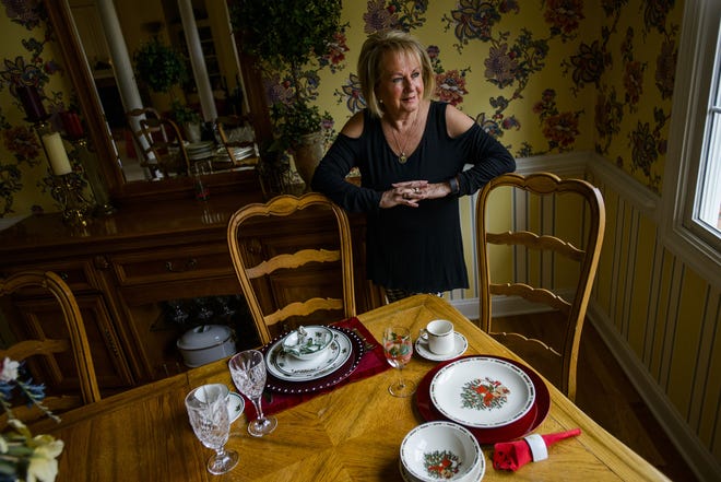 Gwen Holtsclaw with her set of Christmas themed china at her home in Fayetteville. [Staff photo by Shane Dunlap]