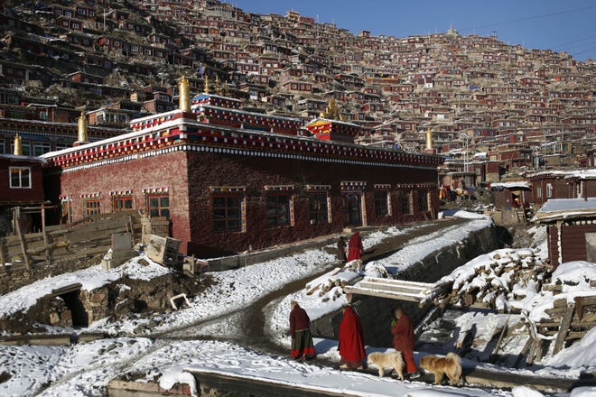 Tibetan nuns walk in 2009 near a mountainside monastery known as Larung Gar in southwest China’s Sichuan province. China says it is rebuilding the major center of Buddhist learning in the country’s west after reports last year that the complex was being demolished and its residents evicted.