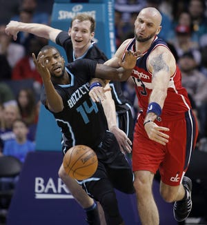 Charlotte Hornets' Michael Kidd-Gilchrist, left, and Cody Zeller, middle, vie for a loose ball with Washington Wizards' Marcin Gortat in Charlotte on Saturday. [AP Photo/Bob Leverone]