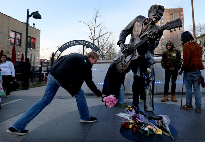 David Gaule, from Springfield, Ill. drops off flowers at the statue of music legend Chuck Berry on the Delmar Loop, in University City on Saturday. Berry died at the age of 90. After hearing Berry died Gaule drove to St. Louis from Springfield to pay his respects. [DAVID CARSON / ST. LOUIS POST-DISPATCH via AP]