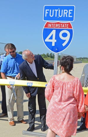 Arkansas Gov. Asa Hutchinson, center, checks out a highway sign prior to a ribbon cutting during the Highway 549/Future 49 dedication and opening ceremony in July 2015.
