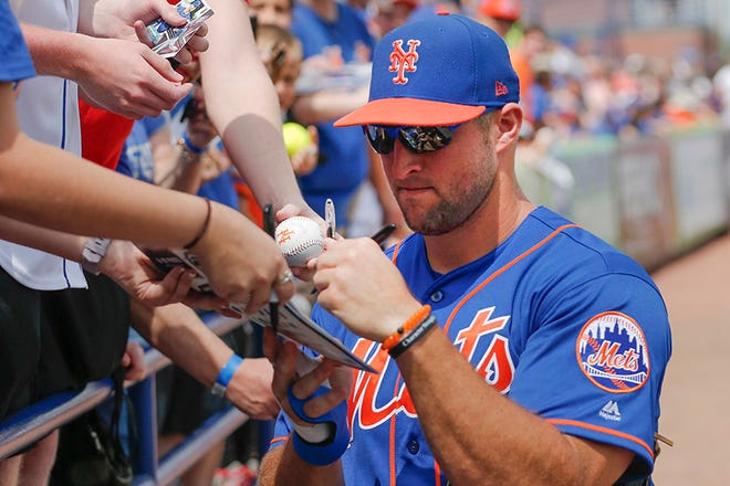 New York Mets' Tim Tebow signs autographs before the first inning of a spring training baseball game against the Miami Marlins Monday, March 13, 2017, in Port St. Lucie, Fla. (AP Photo/John Bazemore)