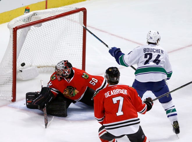 Vancouver Canucks' Reid Boucher (24) scores past Chicago Blackhawks goalie Corey Crawford (50) as Brent Seabrook watches during the second period of an NHL hockey game Tuesday, March 21, 2017, in Chicago. (AP Photo/Charles Rex Arbogast)