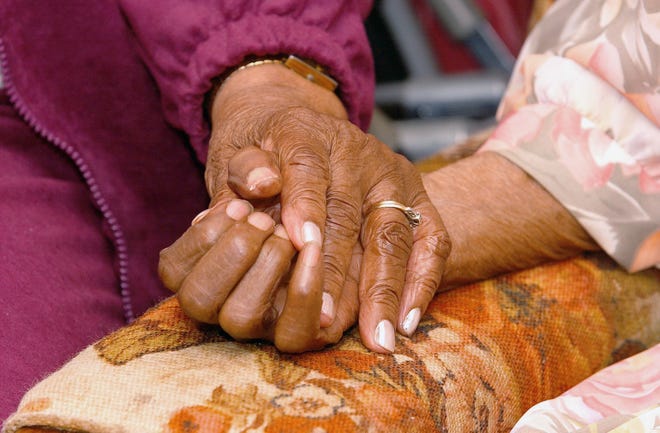 FILE - In this April 1, 2005 file photo, an 81-year-old woman holds the hand of her 100-year-old mother in Tuscaloosa, Ala. A survey conducted in late 2016 finds many pessimistic feelings held by people earlier in life take an optimistic turn as they move toward old age. Even hallmark concerns of old age _ about declining health, lack of independence and memory loss _ lessen as Americans age. (Dan Lopez/The Tuscaloosa News via AP)
