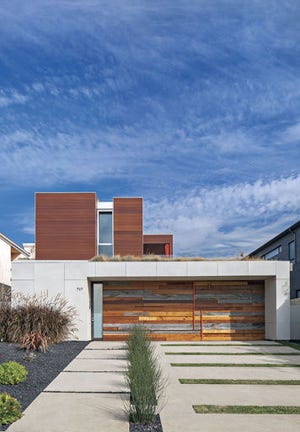 This undated photo taken in Santa Monica, Calif., shows a panelized house that was designed and built by Minarc, a prestigious company in southern California. The facade of the garage door, a focal point of the house, was created with scrap pieces of wood and left over quartz from the interior countertops. The house is featured in the book "prefabulous Small Houses" by Sheri Koones.(Art Gray/Sheri Koones via AP)