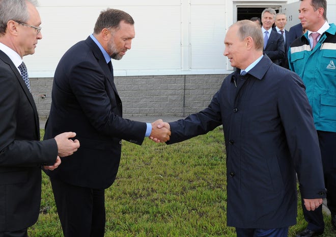 In this Sept. 19, 2014, file-pool photo, Russian President Vladimir Putin, right, shakes hands with Russian metals magnate Oleg Deripaska while visiting the RusVinyl plant in Kstovo, in Russia's Nizhny Novgorod region. President Donald Trump's former campaign chairman, Paul Manafort, secretly worked for Deripaska, a Russian billionaire, to advance the interests of Putin a decade ago and proposed an ambitious political strategy to undermine anti-Russian opposition across former Soviet republics. THE ASSOCIATED PRESS