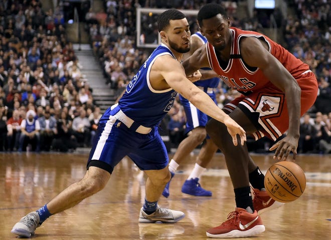 Toronto Raptors guard Fred VanVleet (left), an Auburn High School graduate, tries to snatch the ball from Chicago Bulls forward Bobby Portis during the second half of an NBA basketball game in Toronto Tuesday, March 21, 2017. VanVleet had six points, three rebounds, one assist and two steals in the Raptors' overtime win. [FRANK GUNN/THE ASSOCIATED PRESS]