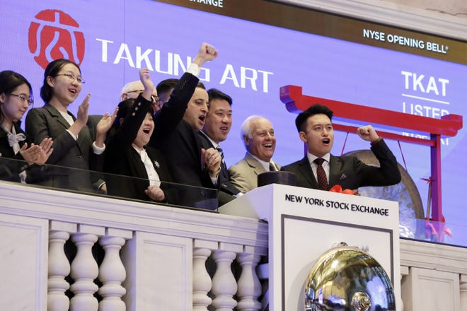 Executives of Takung Art Co., Ltd., from Hong Kong, celebrate as they ring the New York Stock Exchange opening bell, Wednesday, March 22, 2017, to mark the up-listing of their company. THE ASSOCIATED PRESS