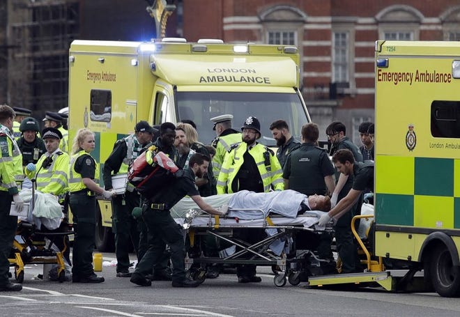 Emergency services transport an injured person to an ambulance, close to the Houses of Parliament in London, Wednesday, March 22, 2017. London police say they are treating a gun and knife incident at Britain's Parliament "as a terrorist incident until we know otherwise." The Metropolitan Police says in a statement that the incident is ongoing. Officials say a man with a knife attacked a police officer at Parliament and was shot by officers. Nearby, witnesses say a vehicle struck several people on the Westminster Bridge. (AP Photo/Matt Dunham)