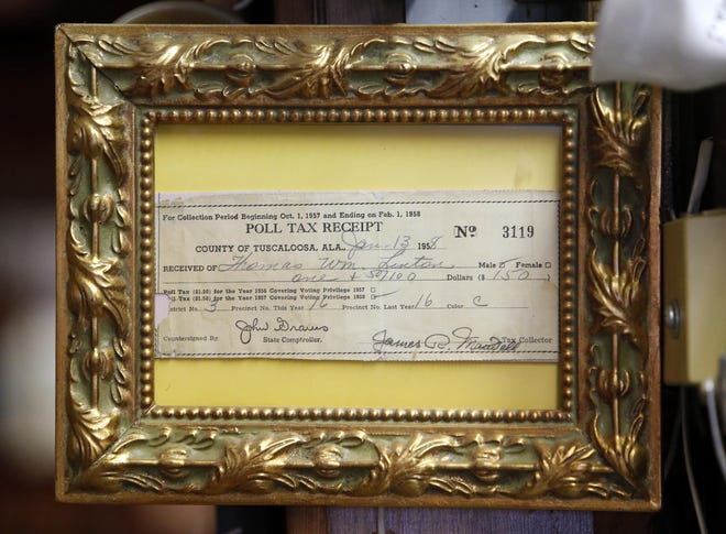 A poll tax receipt belonging to Thomas Linton hangs framed inside Howard & Linton's Barbershop on T.Y. Rogers Jr. Avenue in Tuscaloosa Tuesday, Nov. 11, 2014. [Staff file photo]
