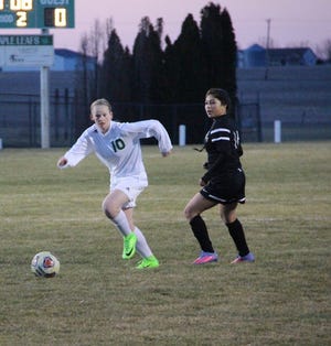 Melanie Parker, left, dribbles up field during Geneseo's season opening win over Galesburg. The Lady Leafs won the match 11-0 on March 21.