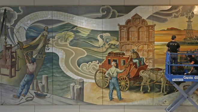 In this Wednesday, March 15, 2017 photo, workers from Unified Fine Arts work to remove the murals from the wall of the TXCN (Texas Cable News) building in Dallas. The murals by nine artists including Perry Nichols will be taken to the Briscoe Center for American History on the University of Texas at Austin campus. Jae S. Lee/The Dallas Morning News via AP