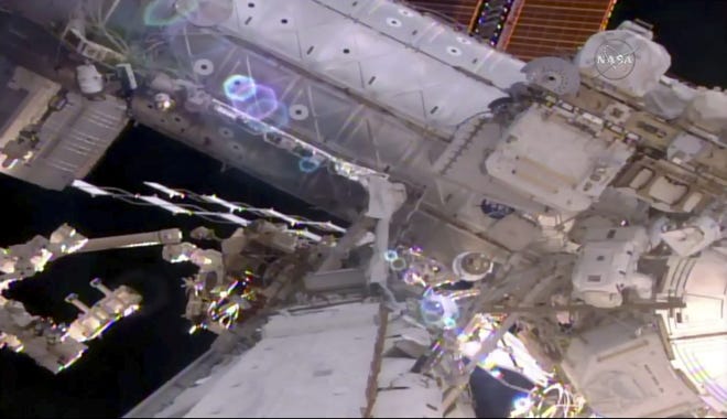 This still image taken from live video provided by NASA shows astronaut Shane Kimbrough, right, working on the International Space Station during a space walk on Friday. [NASA / AP]