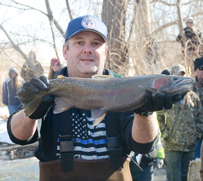 Dan Mulhall of the Region 8 office of the NYSDEC holds a large rainbow trout during their annual sampling of Naples Creek on Thursday. [Jack Haley/Messenger Post Media]