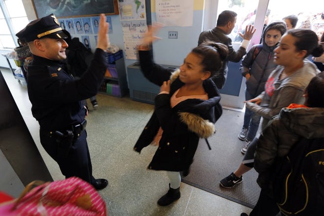 New Bedford police officers, Capt. Derek Belong and Chief Joseph Cordeiro give Hathaway School students high fives as they enter the building as part of the High 5 program meant to cast police officers in a positive light with young children.

 [ PETER PEREIRA/THE STANDARD-TIMES/SCMG ]