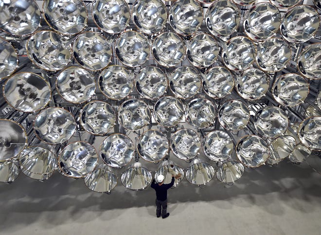Engineer Volkmar Dohmen stands in front of xenon short-arc lamps Tuesday in the DLR German national aeronautics and space research center in Juelich, Germany. The lights are part of an artificial sun that will be used for research purposes. [CAROLINE SEIDEL/DPA VIA AP]