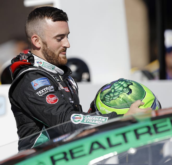 Austin Dillon puts on his helmet on pit row prior to the qualifying session for the NASCAR auto race at Auto Club Speedway in Fontana, Calif. on Friday. [ALEX GALLARDO / ASSOCIATED PRESS]