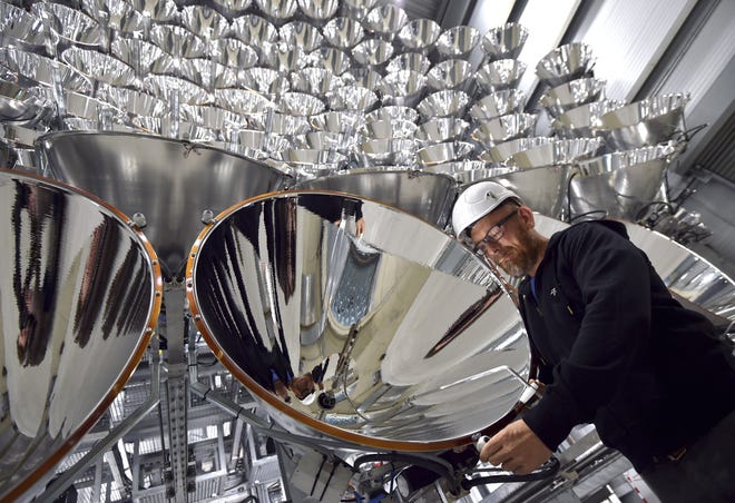 In this March 21, 2017 photo engineer Volkmar Dohmen stands in front of xenon short-arc lamps in the DLR German national aeronautics and space research center in Juelich, western Germany. The lights are part of an artificial sun that will be used for research purposes. [Photo: Caroline Seidel/dpa via AP]