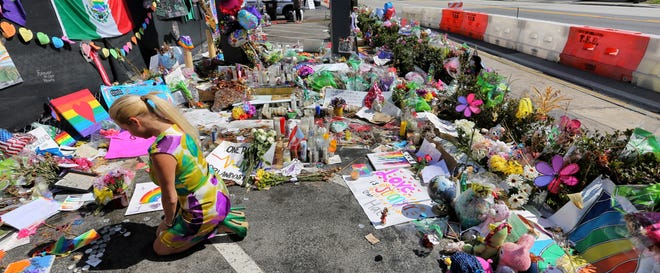 In a Monday, July 11, 2016 file photo, visitors continue to flock to the Pulse nightclub to their pay their respects in Orlando. Forty-nine people were shot and killed at the club, June 12. U.S. District Judge Kenneth Marra said says a lawsuit brought by victims of the Orlando nightclub massacre against the gunman's employer and wife may be tossed out of federal court. [JOE BURBANK / ORLANDO SENTINEL via AP]