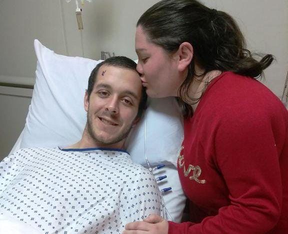 Amanda Snow of Raynham kisses her boyfriend Kyle prior to his surgery to remove a malignant brain tumor in February.