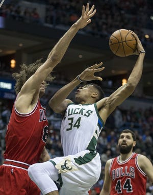 Chicago's Robin Lopez tries to stop Milwaukee's Giannis Antetokounmpo from shooting the ball Sunday in Milwaukee. [TOM LYNN/THE ASSOCIATED PRESS]