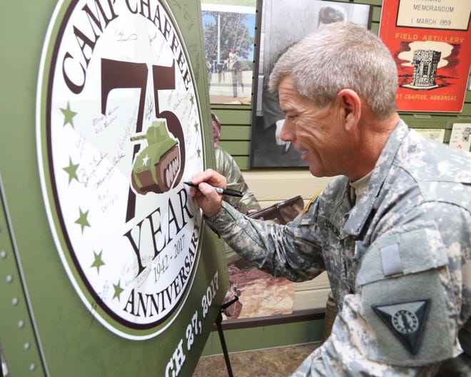 Master Sgt. Russell Vanzant with the Fort Chaffee Joint Maneuver Training Center joins other signatories as he signs his name to the Camp Chaffee 75th Anniversary memorial poster Saturday, March 25, 2017, during the camp's anniversary celebration at the Fort Chaffee Historic District. The special event included a reception for special military guest, city and county officials as well as free haircuts at the Chaffee Barbershop Museum. [JAMIE MITCHELL/TIMES RECORD]