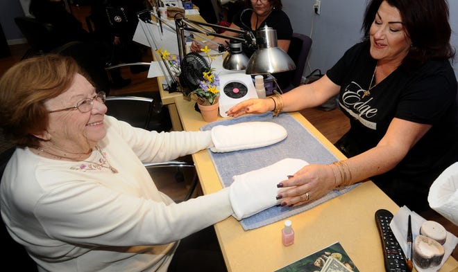 Dolores Sepich, of Cinnaminson, gets a hand treatment from Shawna Cattani, of Burlington Township, at Edge Salon & Spa in Moorestown, which is hosting Spaw Day events to benefit the Paw It 4ward Foundation.
