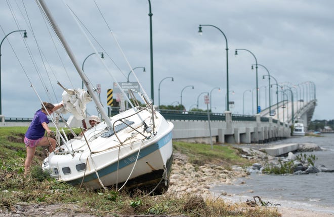 A sailboat washed ashore by Hurricane Matthew at the Jensen Beach Causeway Park in Jensen Beach on Oct. 7, 2016. Hurricane Matthew stayed just far enough offshore to spare Central Florida a direct hit, but remained a Category 3 storm moving north along the Atlantic coast. [AP FILE]