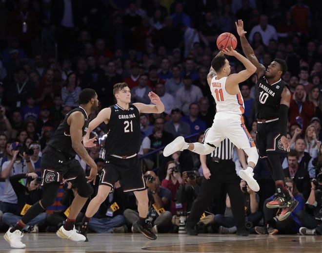 Florida guard Chris Chiozza (11) puts up a shot against South Carolina guard Duane Notice (10) during the second half of the East Regional championship game of the NCAA Tournament on Sunday in New York. [AP Photo / Julio Cortez]