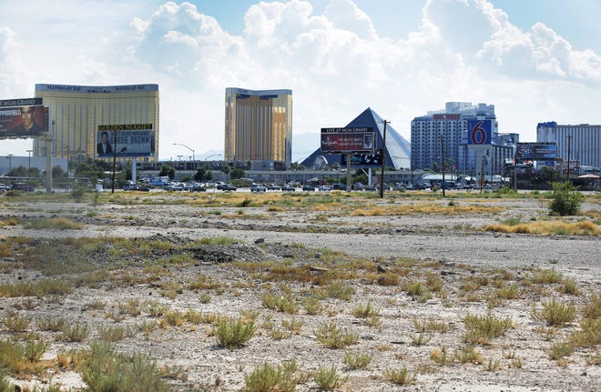 In this July 1, 2016, file photo, a vacant lot that is the site of a proposed football stadium sits near McCarran International Airport in Las Vegas. NFL owners approved the Oakland Raiders' move to Las Vegas on Monday morning, March 27, 2017, at the league meetings. THE ASSOCIATED PRESS