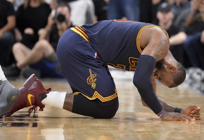 Cleveland Cavaliers forward LeBron James falls to the floor during the second half of Monday's loss to the Spurs.