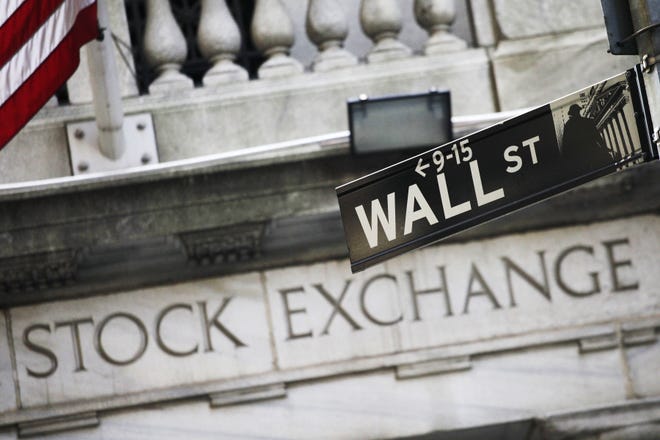 This July 16, 2013, file photo, shows a Wall Street street sign outside the New York Stock Exchange. THE ASSOCIATED PRESS