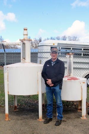 Siskiyou County Deputy Ag Commissioner and Sealer Larry Hicks stands between two provers – devices used to accurately measure things like propane.