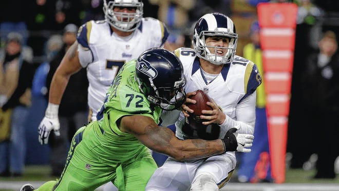 Seahawks defensive lineman Michael Bennett brings down Rams quarterback Jared Goff last season. (Associated Press)