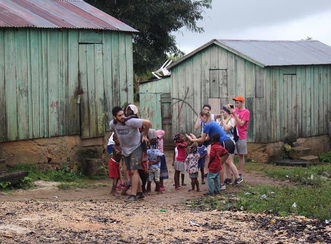 Members of the Saugatuck High School Interact Club play with children in Batey 106 in the Dominican Republic. The service-oriented club is looking to build an expansion on Batey 106's school. Contributed