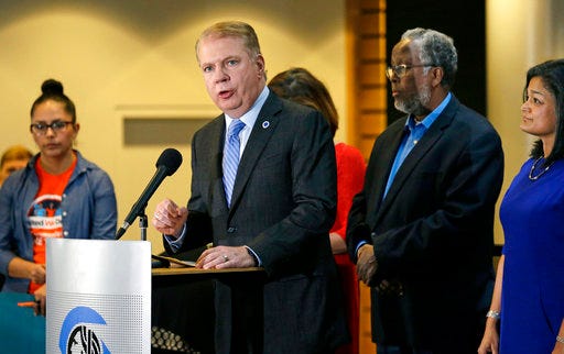 FILE - In this Nov. 9, 2016, file photo, Seattle Mayor Ed Murray, second left, speaks at a post-election event of elected officials and community leaders at City Hall in Seattle. On Wednesday, March 29, 2017, Murray announced that Seattle is suing President Donald Trump over his executive order that threatens to withhold federal funds from communities that refuse to cooperate with efforts to find and deport immigrants in the country illegally. (AP Photo/Elaine Thompson, File)