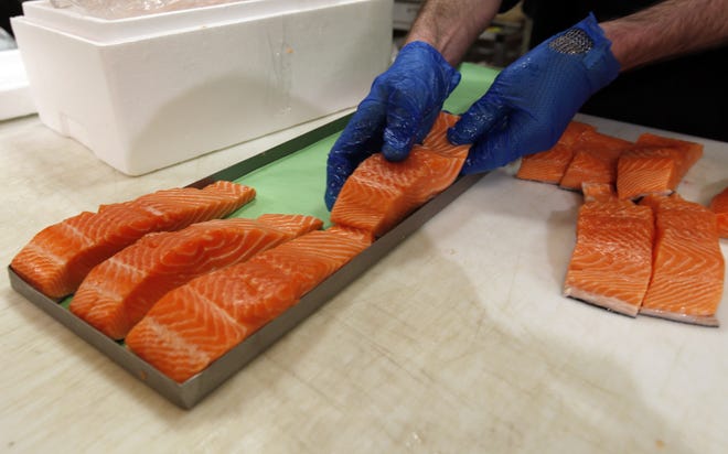 Canadian certified organic farm-raised King Salmon filets are placed on a tray in a store in Fairfax, Virginia. (AP Photo/Alex Brandon)