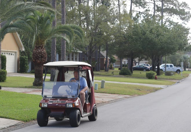A man drives a golf cart through the Panama Country Club in Lynn Haven in 2015. Golf carts currently are allowed only in certain subdivisions and within a half-mile of a golf course. [NEWS HERALD FILE PHOTO]